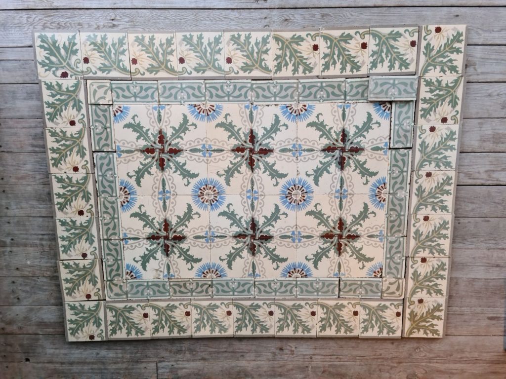 Antique ceramic tiles with a pattern of cornflowers and thistles