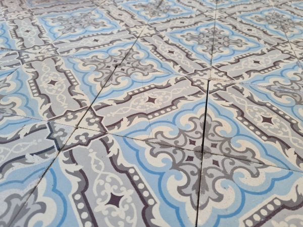 Old patterned tiles in shades of grey and ice blue