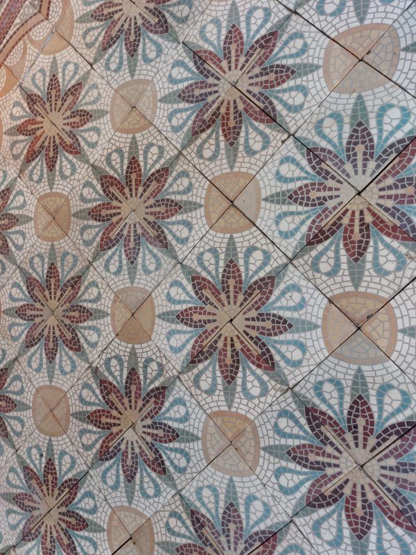 Antique ceramic floor with four-tile flower pattern