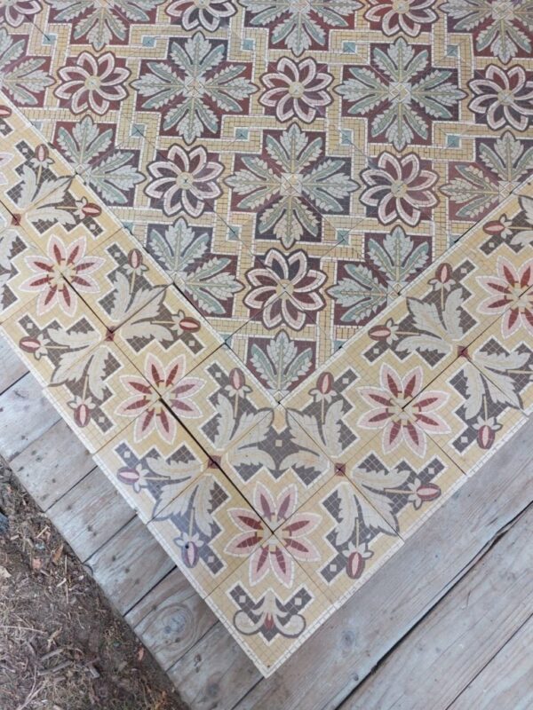 Antique floor tiles with flower motif with a touch of pink, yellow and green and original double borders