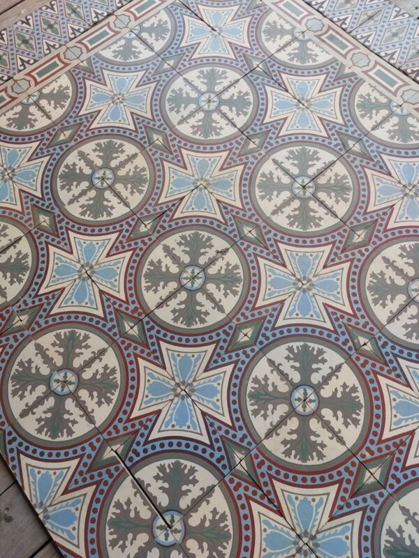 Antieke vloertegels met bloempatroon in een kleurenpalet met blauw en groen als dominante kleuren