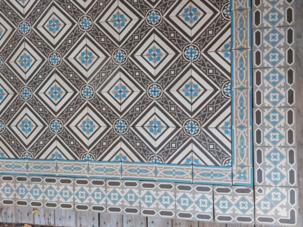Encaustic floor tiles with double border in a cool color palette with shades of grey and blue