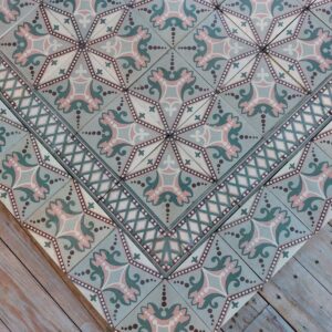 Antieke keramische tegelvloer met originele dubbele boord in tinten van oud roos en groen