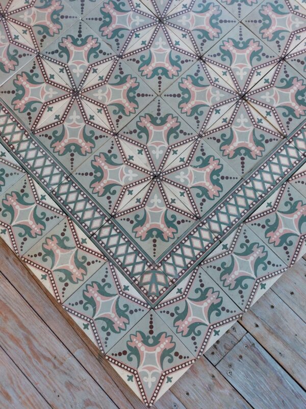 Antique encaustic floor with double border and star pattern in shades of pink and green