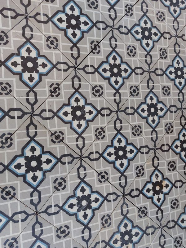 Antique reclaimed encaustic patterned tiles with a classical design in shades of grey