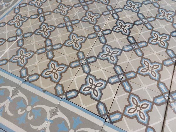 Oude vloertegels met geometrisch patroon met dominante kleuren blauw en grijs