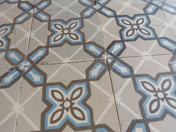 Reclaimed encaustic floor with geometric motif and dominant colors grey and blue