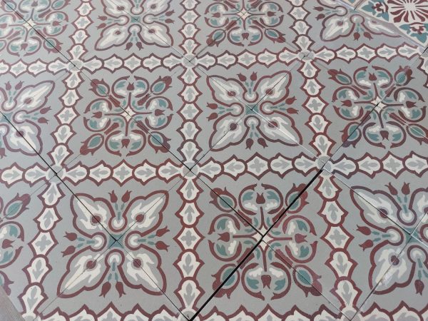 Franse oude vloertegels met bloempatroon en bijhorende rand in tinten van groen, grijs en bordeaux