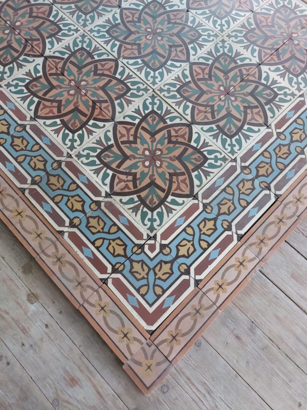 Antieke keramische patroontegels met bloemmotief en bijhorende randtegels