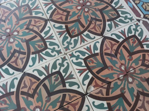 Antique ceramic reclaimed tiles with flower pattern and dominant colors orange and green