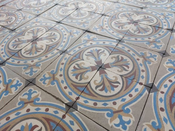 Encaustic old tiles with a circular pattern and a bold flower theme in a cool color palette