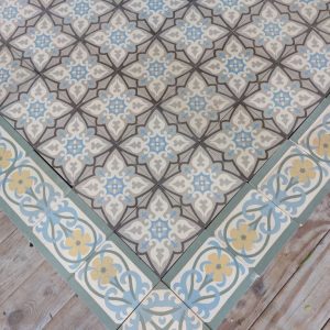 Antieke keramische vloer in een geometrisch design met dominante kleuren groen, blauw en grijs