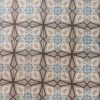 Oude keramische vloertegels in een geometrisch design met een abstract bloemmotief