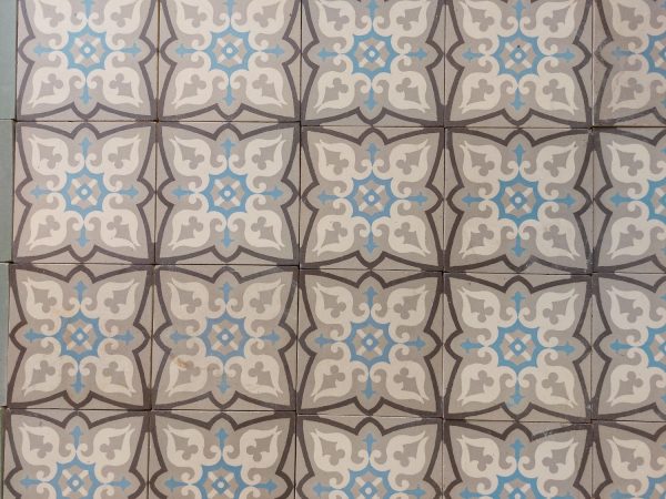 Reclaimed encaustic floor tiles with a geometrical design in a cool color pallete