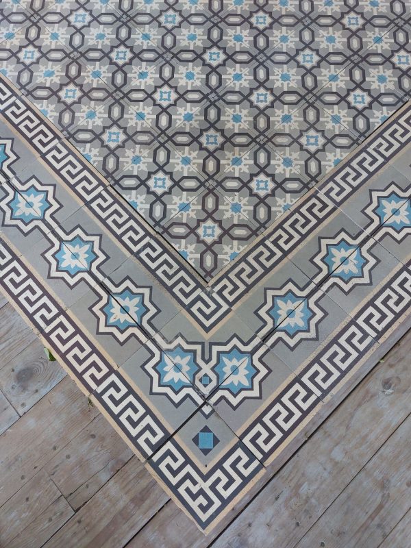 Antieke keramische vloertegels met geometrisch patroon en bijhorende randtegels