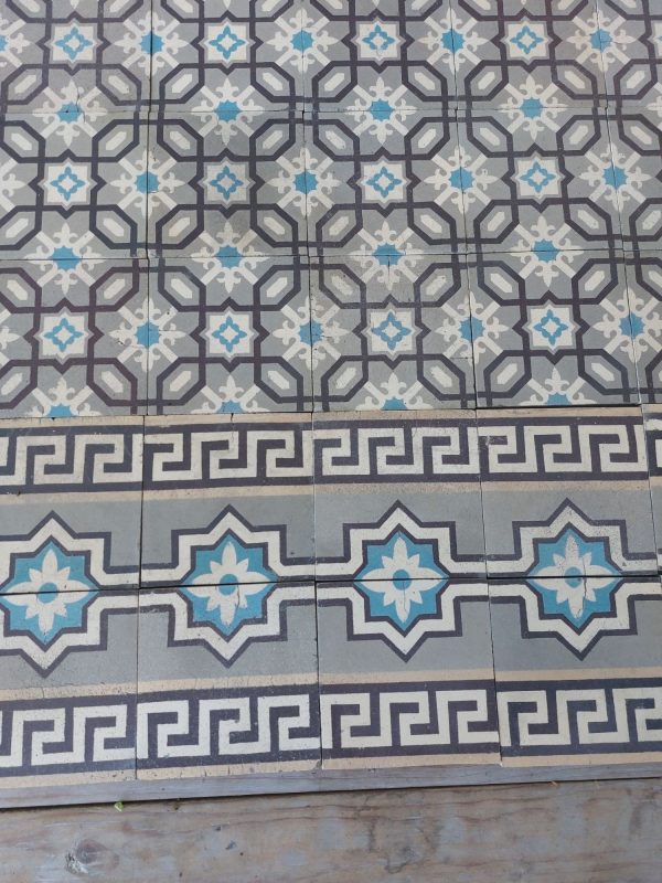 Antieke keramische vloertegels met geometrisch patroon en dubbele boord
