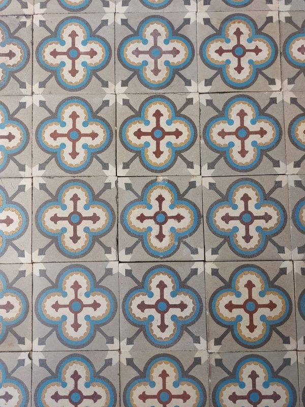 Reclaimed encaustic tiles with geometric pattern and dominant colors blue, grey and red