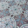 Antieke vloertegels in een fleurig mozaïekpatroon met roos, bordeaux, blauw en wit als dominante kleuren
