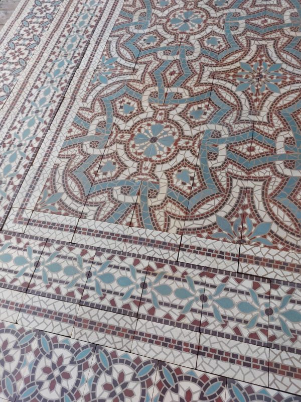 Antique mosaic flower themed floor with a twelf-tile pattern and matching borders