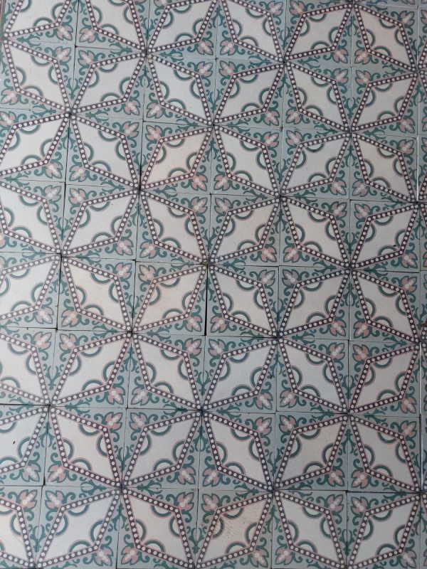 Art-Nouveau tiles with a dotted star motif in a palette of soft pink and green