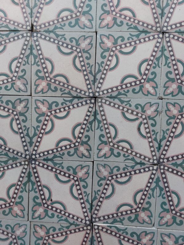 Encaustic antique tiles with a dotted star pattern in a palette of soft pink and green