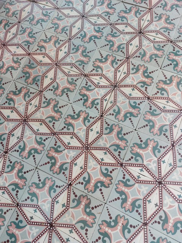 Old encaustic tiles with a star pattern in a color palette soft green and pink