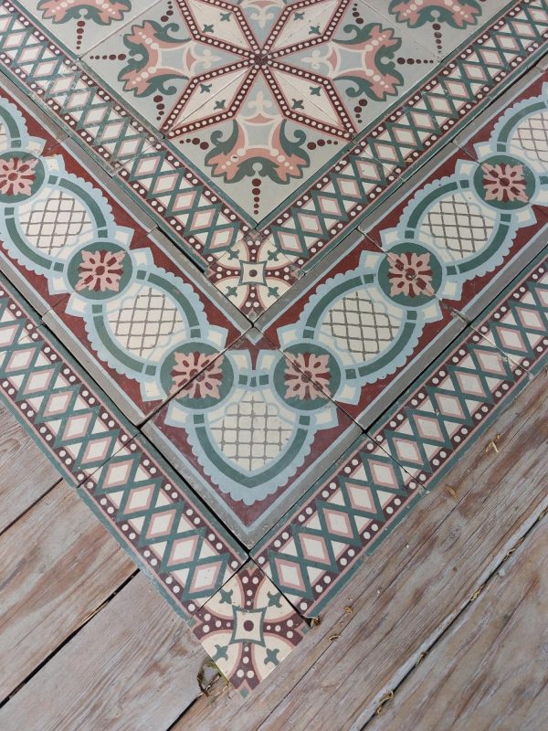 Art-Nouveau floor tiles in a palette of soft green and old rose with matching border tiles