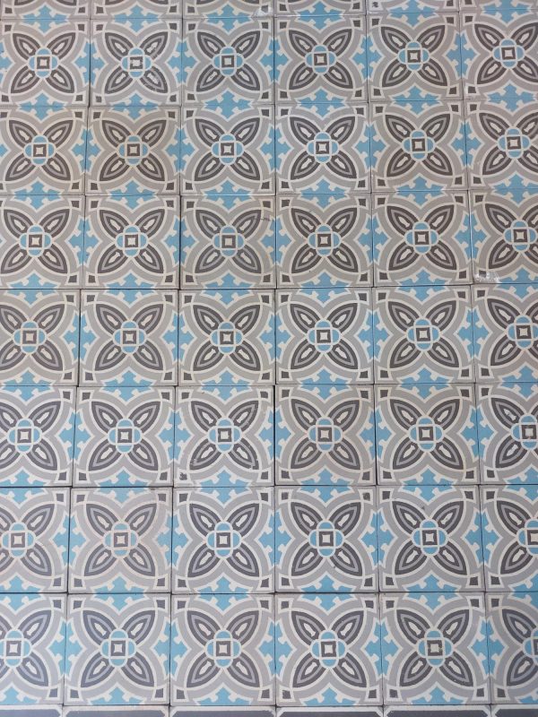 Reclaimed encaustic floor tiles with a geometric design in shades of grey and blue