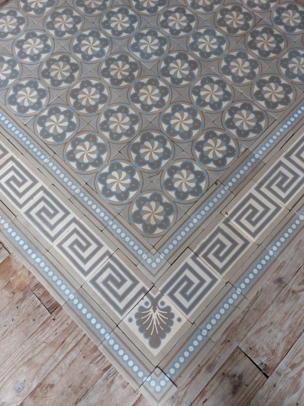 Encaustic reclaimed floor in shades of brown, white and blue with original triple border