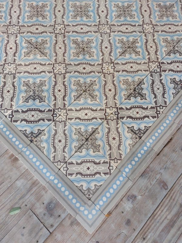 Antique reclaimed ceramic floor with matching border in a cool color palette with grey and blue as dominant colors