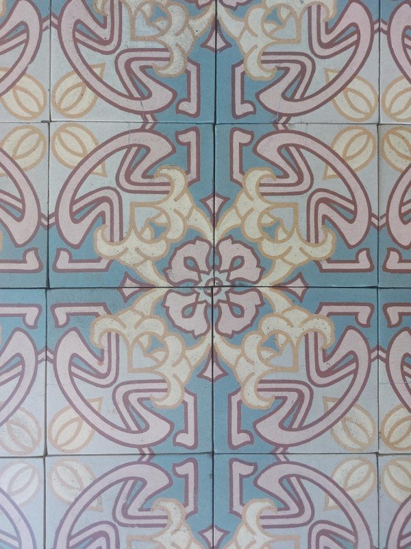 Oude vloertegels circa 1910 met Art-nouveau bloementhema met dominante kleuren roos en blauw