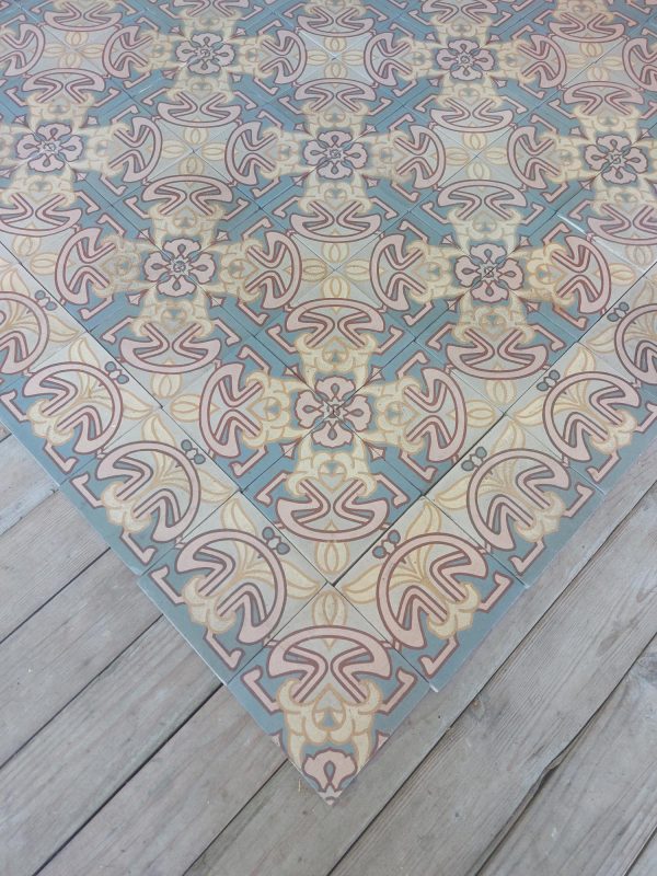Antieke Art-Nouveau keramische vloer in tinten van roos en blauw met bijhorende randtegels